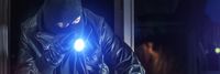Einbrecher mit Taschenlampe geht im dunkeln durch ein Einfamilienhaus